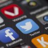 A detailed close-up of social media icons on a smartphone screen, including Facebook and Twitter.